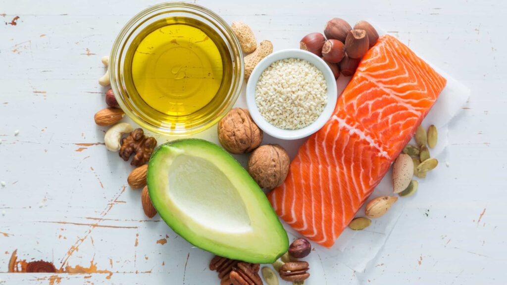 Immagine raffigurante varie fonti di lipidi (avocado, olio di oliva, salmone, nocciole, noci)