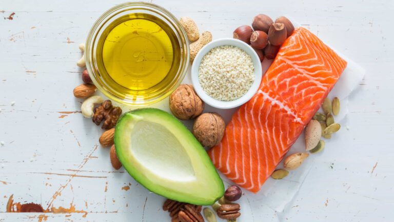 Immagine raffigurante varie fonti di lipidi (avocado, olio di oliva, salmone, nocciole, noci)