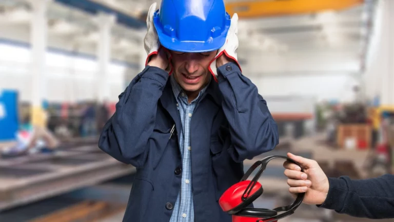 un uomo a lavoro si copre le orecchie perché c'è troppo e gli porgono delle cuffie per aiutarlo a combattere l'inquinamento acustico