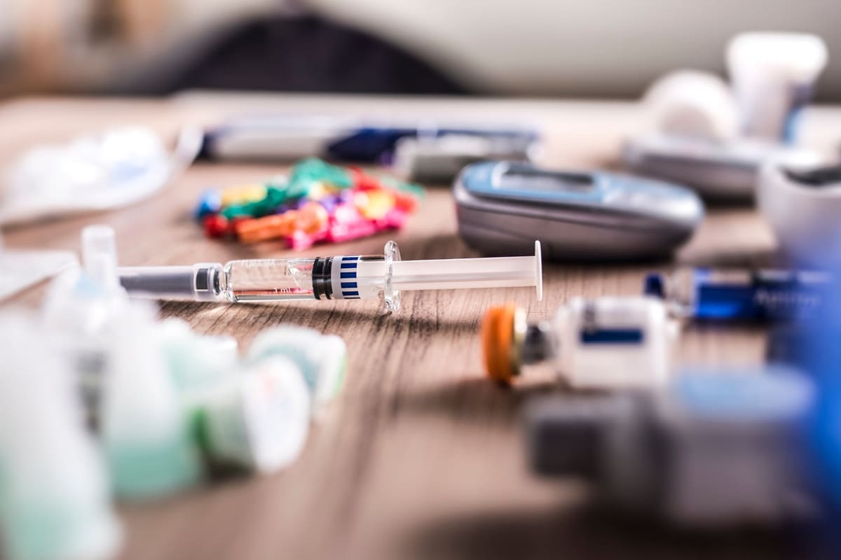 Strumenti medici per la gestione della glicemia e dell’insulina Siringa e dispositivi medici su un tavolo per la somministrazione di insulina e la misurazione della glicemia, simbolo della regolazione ormonale tra insulina e glucagone