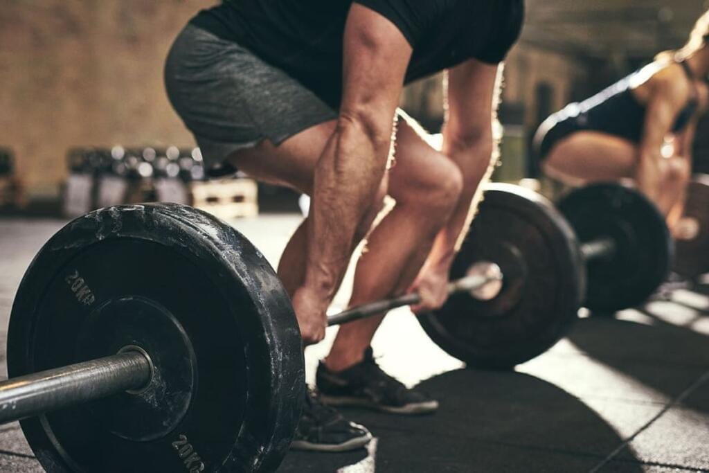 Allenamento di forza: il ruolo del sollevamento pesi nella salute metabolica persona che esegue un sollevamento da terra con bilanciere durante un allenamento di forza