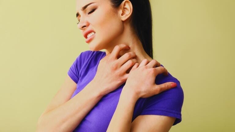 Ragazza alle prese con una fastidiosa allergia al nichel si gratta collo e spalla