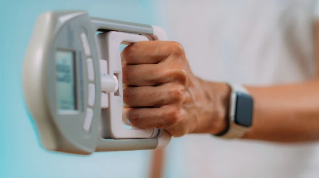 Mano che misura la forza di presa con un dinamometro digitale per valutare forza e controllo della presa