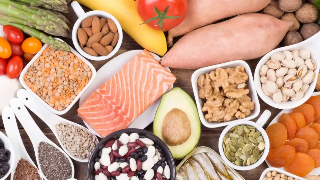 limenti ricchi di potassio disposti a vista dall’alto: frutta e verdura fresche come banane, avocado e spinaci