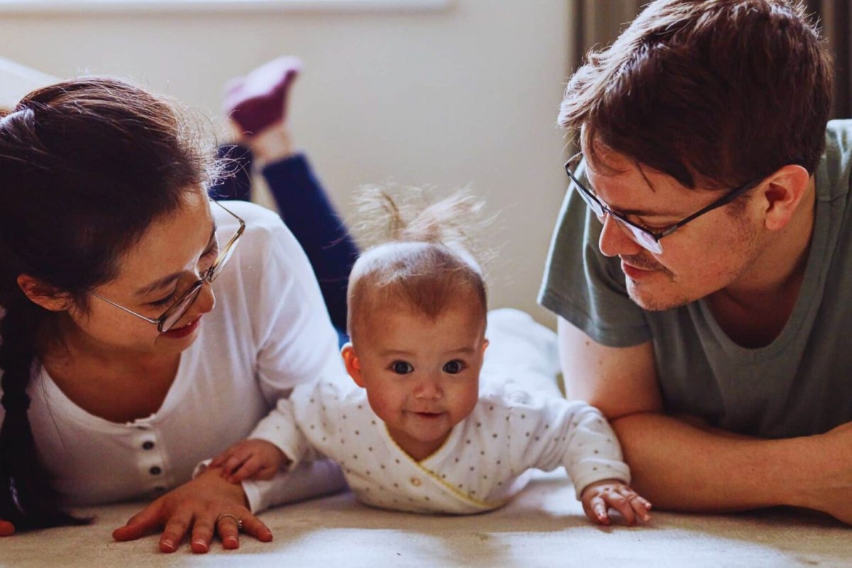 tummy time per adulti padre e madre sdraiati affianco al proprio neonato